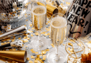 glasses of champagne sitting on a table surrounded by New Year's Eve party supplies